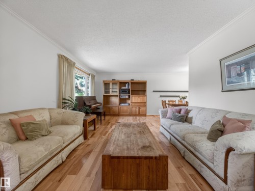 Hardwood-finish flooring throughout, crown molding, and a built-in wood-finish shelving unit - 18416 90 Avenue, Edmonton, AB 