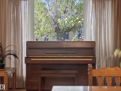 Full-height window with sheer curtains, offering natural illumination - 18416 90 Avenue, Edmonton, AB 