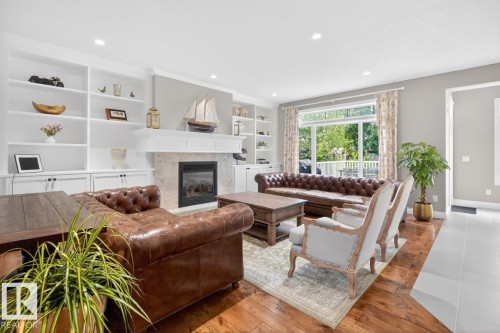 Large Living Room featuring Gas Fireplace, South West Facing Windows, and built in Shelving/Cabinets - 5016 213 Street, Edmonton, AB 