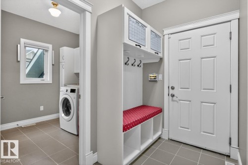 Entryway mudroom featuring built-in storage, bench seating, and coat hooks - 5016 213 Street, Edmonton, AB 