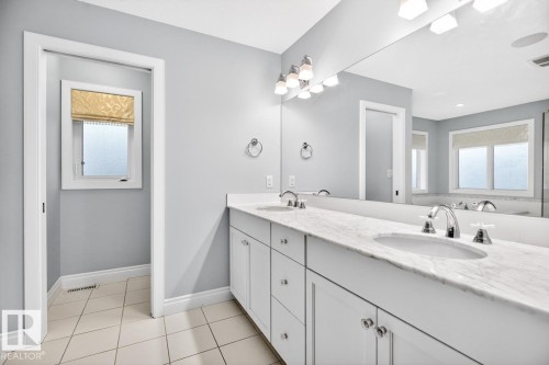 Spacious bathroom featuring a corner soaking tub, glass shower, heated flooring, double vanity, and separate water closet - 5016 213 Street, Edmonton, AB 