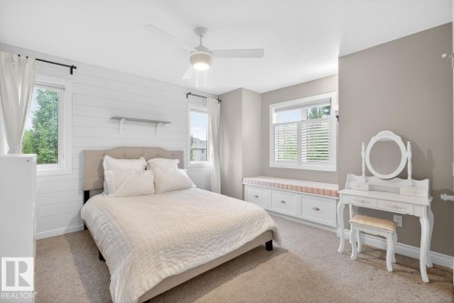 Bedroom featuring shiplap accent wall, corner South East Facing windows with built-in window seat with storage drawers - 5016 213 Street, Edmonton, AB 