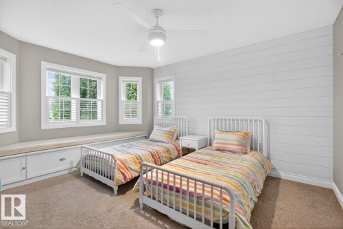 Bedroom featuring shiplap accent wall, corner North East Facing windows with built-in window seat with storage drawers - 5016 213 Street, Edmonton, AB 