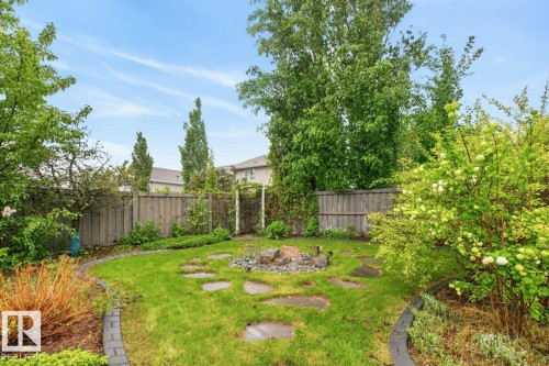 Large South Facing Backyard Space (1259 m@ / 0.31 Acres) featuring Apple Trees, Pear Trees, Cherry Trees, Berry Bushes, Irrigation System, Fire Pit, and Fountain - 5016 213 Street, Edmonton, AB 