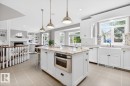 Large White Cabinet Kitchen featuring Granite Counters, Sub-Zero Refrigerator, Dishwasher (2025), Garburator (2025), Electric Stove (2026), Large Walk Through Pantry, and Prep Sink in Island - 5016 213 Street, Edmonton, AB 