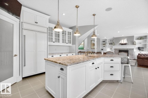 Large White Cabinet Kitchen featuring Granite Counters, Sub-Zero Refrigerator, Dishwasher (2025), Garburator (2025), Electric Stove (2026), Large Walk Through Pantry, and Prep Sink in Island - 5016 213 Street, Edmonton, AB 