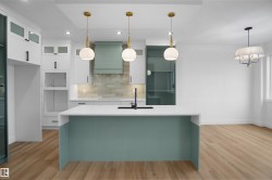 Modern kitchen featuring a spacious island with a white countertop and contrasting teal base - 