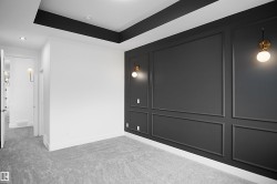 Interior room featuring a textured accent wall with applied molding, brass and frosted glass sconces, and recessed lighting - 