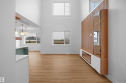 Soaring ceilings and light wood-finish flooring define this open-concept space - 