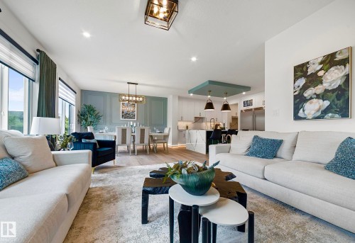 Open-concept living space featuring wood-finish flooring, recessed lighting, and a contemporary chandelier - 16607 8 Street, Edmonton, AB 