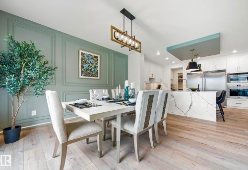 Open-concept dining area featuring a paneled accent wall and wood-finish flooring - 16607 8 Street, Edmonton, AB 