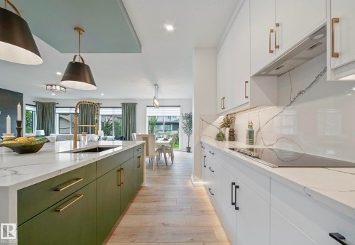 Modern kitchen featuring a waterfall island with an undermount sink and brass-finish faucet - 16607 8 Street, Edmonton, AB 