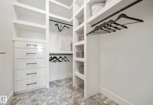 Custom closet system featuring built-in shelving, hanging rods, and a five-drawer dresser with gloss white fronts and matte black hardware - 16607 8 Street, Edmonton, AB 