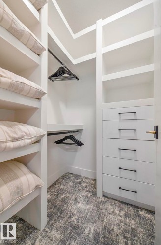 Custom closet system featuring built-in shelving, hanging rods, and a five-drawer dresser with matte black hardware - 16607 8 Street, Edmonton, AB 