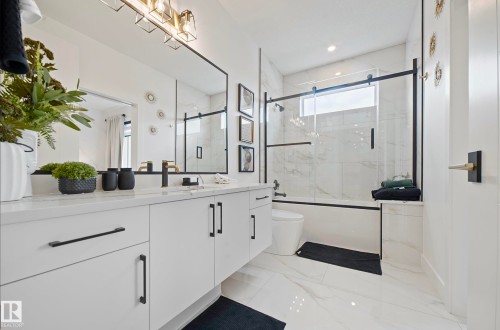 Dual vanity with solid surface countertops, matte black hardware, and custom mirrors - 16607 8 Street, Edmonton, AB 