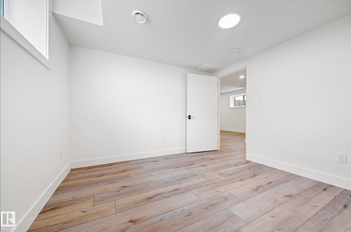 Bright interior space featuring light wood-finish flooring, white walls, and recessed ceiling lighting - 16607 8 Street, Edmonton, AB 