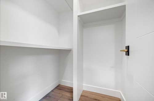 Built-in shelving with white finish, wood-finish flooring, and crisp white baseboards - 16607 8 Street, Edmonton, AB 