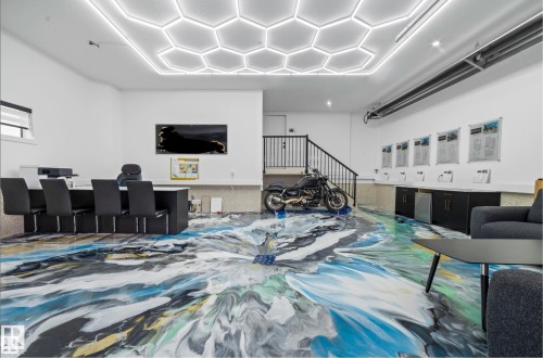 Expansive room featuring a unique abstract-patterned floor and contemporary hexagonal ceiling lighting - 16607 8 Street, Edmonton, AB 