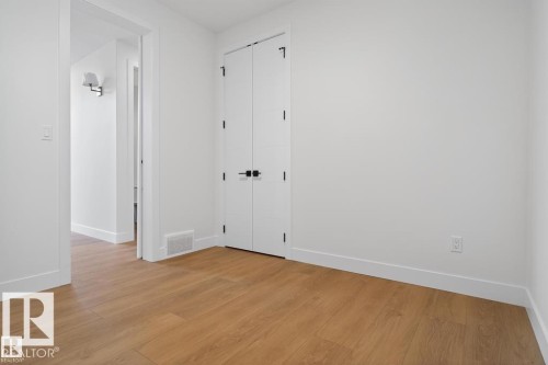 Light wood-finish flooring with white baseboards and walls - 19 Rosa Crescent, St. Albert, AB 