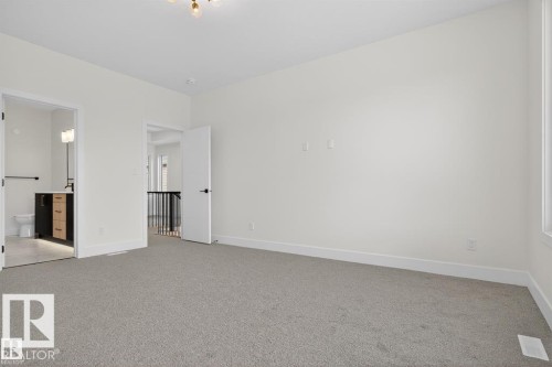 Spacious room featuring neutral carpet, white walls, and a modern ceiling light fixture - 19 Rosa Crescent, St. Albert, AB 
