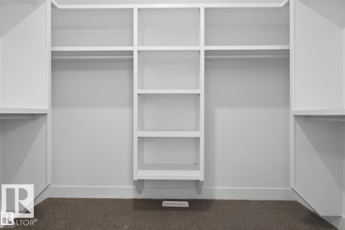 Built-in closet system featuring white shelving and hanging rods - 19 Rosa Crescent, St. Albert, AB 
