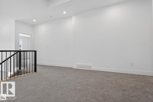Upper-level landing featuring neutral carpeting, white wall finishes, and recessed lighting - 19 Rosa Crescent, St. Albert, AB 