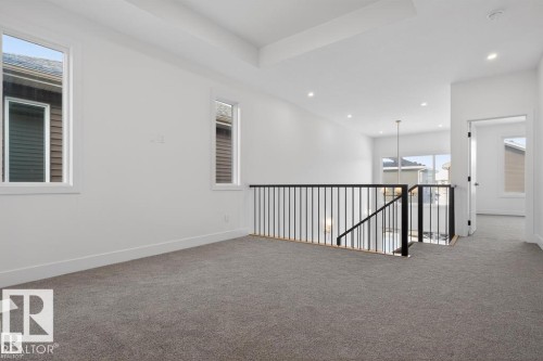Upper-level landing featuring plush gray carpeting and white walls - 19 Rosa Crescent, St. Albert, AB 
