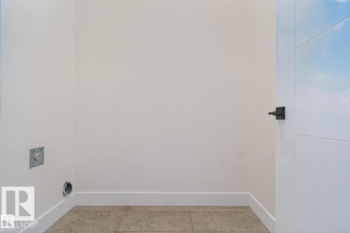 Dedicated laundry area featuring a floor drain, electrical outlet, and vent hookup - 19 Rosa Crescent, St. Albert, AB 