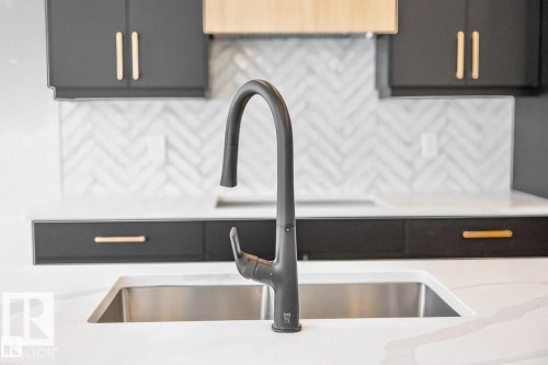 Modern kitchen featuring a matte black gooseneck faucet, an undermount stainless steel sink, and white countertops - 19 Rosa Crescent, St. Albert, AB 