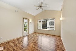Room featuring wood-finish flooring, a vaulted ceiling, and a ceiling fan - 