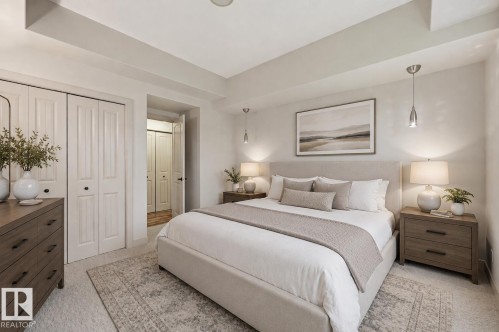 Carpeted bedroom featuring bi-fold closet doors, recessed lighting, and a textured area rug - 50 2565 Hanna Crescent, Edmonton, AB 
