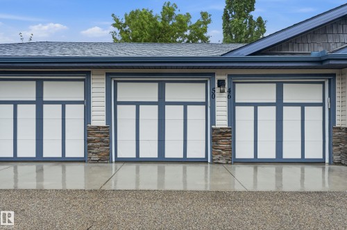 Triple-bay garage featuring contemporary doors with frosted glass panels and blue trim - 50 2565 Hanna Crescent, Edmonton, AB 