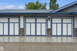 Triple-bay garage featuring contemporary doors with frosted glass panels and blue trim - 