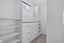 Custom closet system featuring built-in shelving, integrated drawers with gold-toned pulls, and a wood-finish countertop accent - 