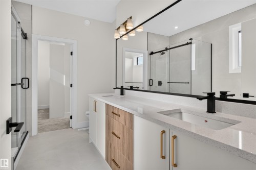 Contemporary bathroom featuring a double vanity with stone countertops, integrated sinks, and matte black faucets - 84 Rosa Crescent, St. Albert, AB - Indoor Photo Showing Other Room