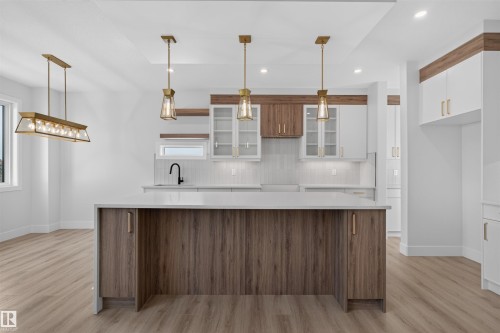 Kitchen featuring a central island with wood-finish cabinetry and a light-toned countertop - 84 Rosa Crescent, St. Albert, AB - Indoor Photo Showing Kitchen With Upgraded Kitchen