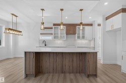 Kitchen featuring a central island with wood-finish cabinetry and a light-toned countertop - 