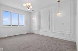 Room featuring decorative wall molding, a large window, and carpeted flooring - 
