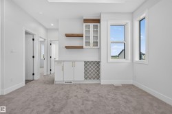 Built-in cabinetry with glass-front uppers, a wine rack, and natural wood-tone floating shelves - 