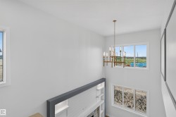 Two-story interior with a modern chandelier, tall ceilings, and multiple windows - 