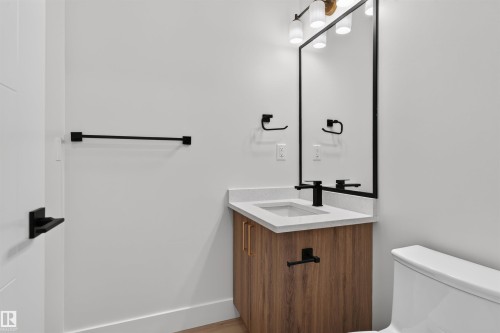 Modern vanity featuring a wood-finish cabinet, light countertop, and integrated sink - 84 Rosa Crescent, St. Albert, AB - Indoor Photo Showing Bathroom