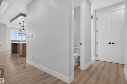 Hallway featuring wood-finish flooring, white baseboards, and a neutral wall color - 