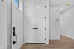 Entryway featuring a white door with modern black hardware and a transom window - 