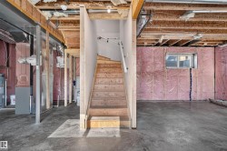 Unfinished basement offering substantial potential for customization, featuring exposed wood joists, concrete flooring, and a framed window opening - 