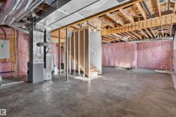 Unfinished basement featuring exposed wood joists, pink insulation, and a concrete floor - 