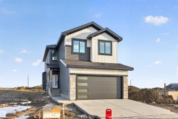 Contemporary two-story residence featuring a dark gray and cream exterior with contrasting trim - 