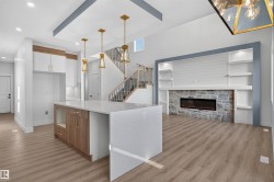 Open-concept living space with wood-finish flooring - 