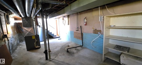 Concrete basement featuring exposed ceiling joists and utility piping - Vegreville, AB - Indoor Photo Showing Basement