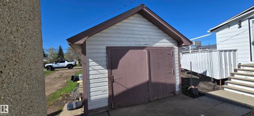 Detached garage with horizontal siding, gable roof, and double barn-style doors - Vegreville, AB - Outdoor With Exterior