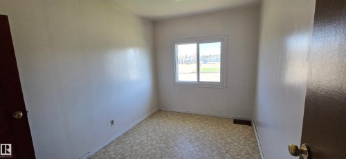 Room featuring light-toned walls, patterned flooring, and a sliding window - Vegreville, AB - Indoor Photo Showing Other Room
